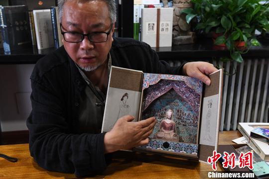 從函盒下方抽出藏書票筆記本時(shí)，佛陀身后的畫面由原先莫高窟第454窟《梵網(wǎng)經(jīng)變圖》變化成第148窟《藥師經(jīng)變圖》?！钇G敏 攝